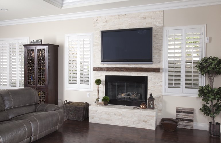 White plantation shutters in a Cleveland living room with dark hardwood floors.